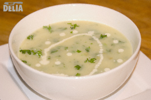 A bowl of extra herby cream of leek and potato soup with a swirl of fresh cream