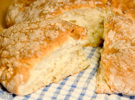 A loaf of soda bread with a wedge cut from the loaf