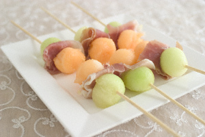 Skewers with slices of Parma ham between balls of honeydew and Japanese melon
