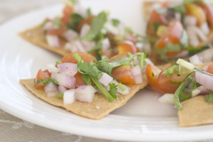 Tostada triangles topped with a tomato, onion and coriander salsa