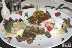 A large platter full of buffet food, left to go to waste