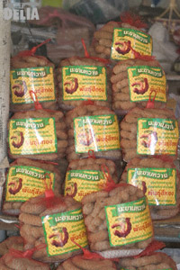 A stack of tamarind pods in nets at a market in Thailand