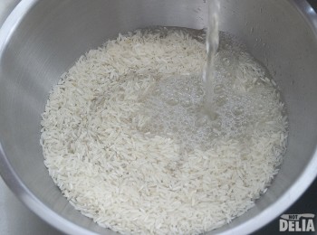 Rice in a steel bowl, about to be washed