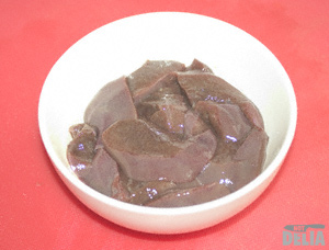Chopped pork liver in a bowl on a meat chopping-board
