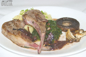 Two fried lamb chops served with mashed potatoes, Portobello mushrooms, spinach and red wine gravy