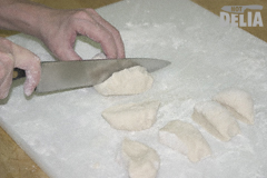 A "sausage" of dough being chopped into small pieces