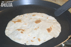 A Chinese pancake frying in a pan