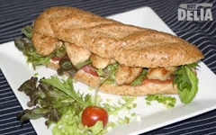 Fried chicken sandwich in a wholemeal roll with a side salad garnish