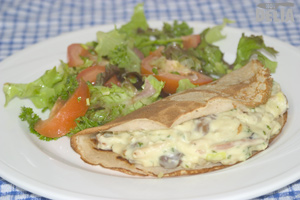 Savoury buckwheat pancake with bacon, mushroom and leek in parsley and mustard sauce and a side salad