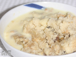 A serving of apple crumble and custard in a dish