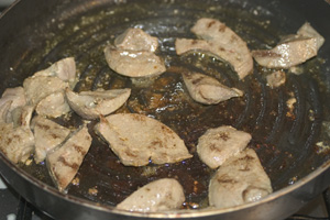 Pieces of pork liver frying in a non-stick pan