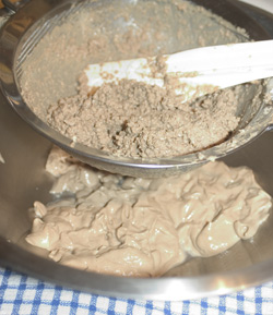 Pork liver residue in a sieve, with a large heap of pork liver paté in a bowl underneath