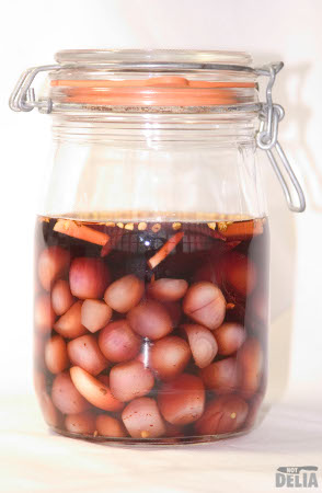 A pickling jar with onions, garlic and chillies in red wine vinegar
