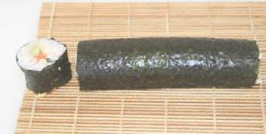 Nori roll lying on the makisu with one end trimmed off