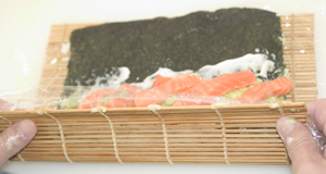 A California roll (uramakizushi) in the early stages of being rolled