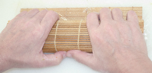 A California roll (uramakizushi) in the final stages of the rolling process