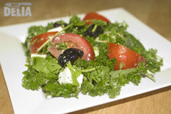 A salad made with courgette, rocket leaves, cream cheese, tomatoes, black olives, parsley and dressing