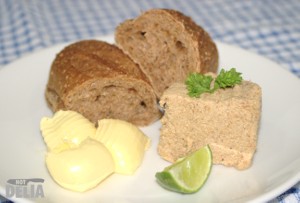 Mushroom paté, served on a plate with wholemeal bread, butter and a lime wedge