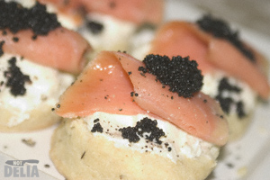 Savoury scones, spread with cream cheese and topped with smoked salmon and black fish eggs