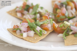 Tostada triangles topped with a tomato, onion and coriander salsa