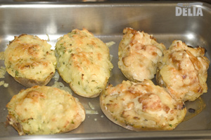 Two twice-baked potatoes with two different fillings in a roasting tin