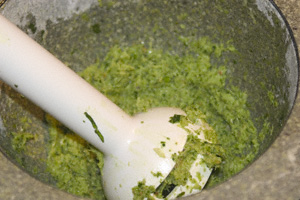 Thai green curry paste in a mortar with a hand-blender head
