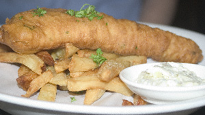 A plate of fish and chips with tartare sauce