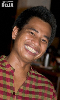 A Thai waiter smiles for the camera