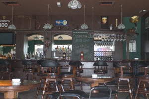 A long bar, lots of empty seats and tables and a high ceiling in Shenanigans on Penang Island, Malaysia
