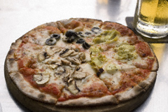 A pizza with artichokes, mushrooms and black olives