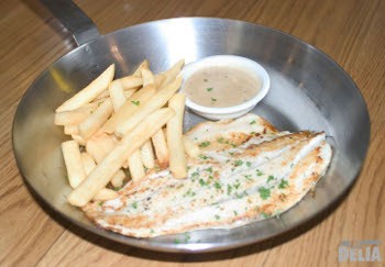 Pan-fried seabass with pepper sauce and chips in a steel "frying-pan"