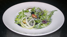 Salad with leaves, salad onion rings, black olives and dressing
