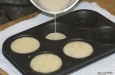 Batter being poured into a Yorkshire pudding
