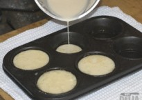 Batter being poured into a Yorkshire pudding