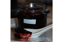 Jar of home-made blackcurrant-jam plus tasting spoon
