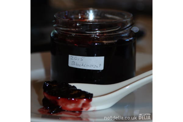 Jar of home-made blackcurrant-jam plus tasting spoon